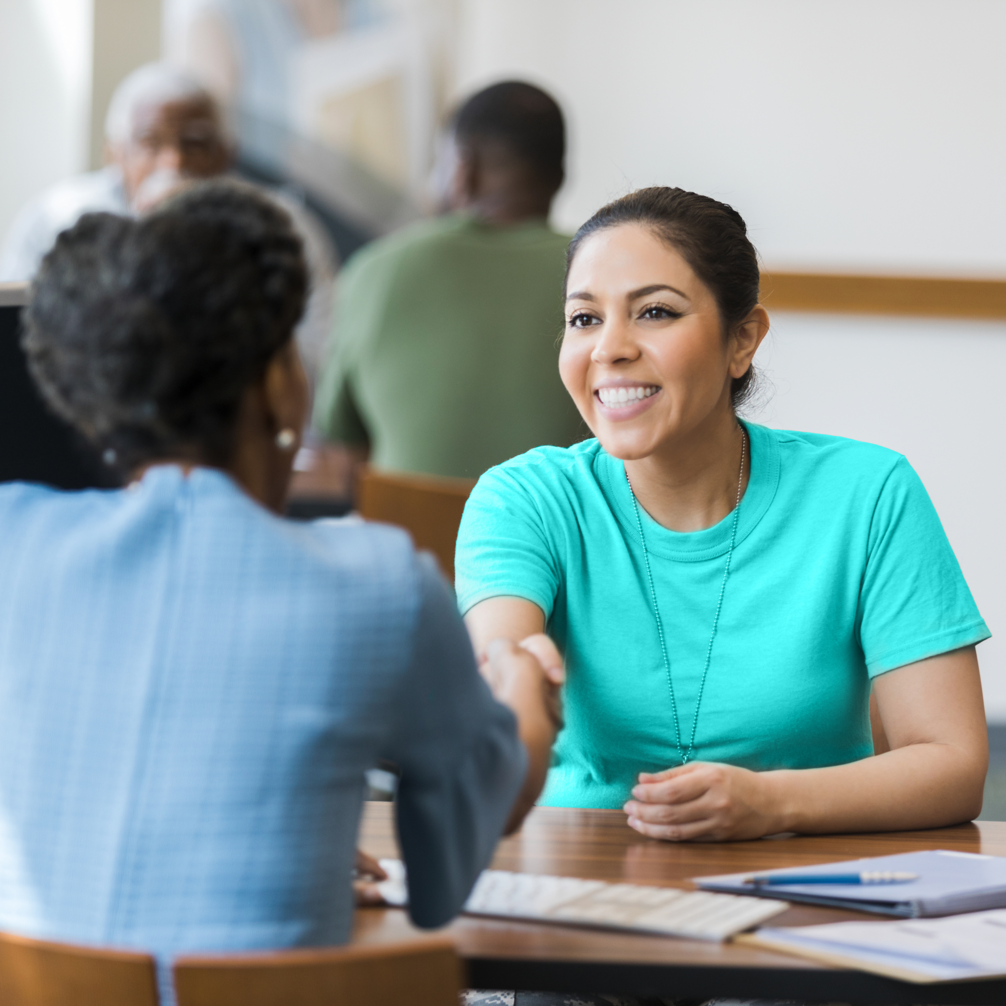 A woman smiling while shaking hands with a financial advisor