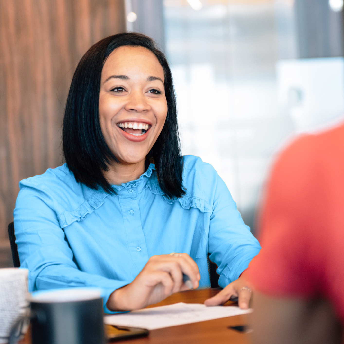 A smiling woman looking at someone off camera