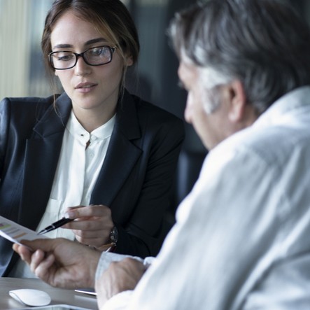 A woman helping an older gentleman with his finances.